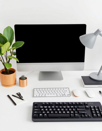 White office desk with computer, keyboard, mouse and plant