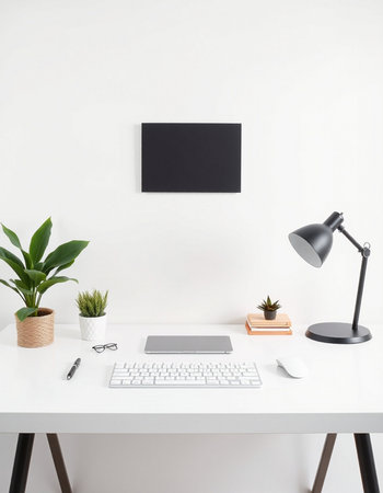 workplace with computer, keyboard, lamp and plant on white table