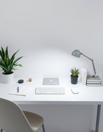 workplace with computer, stationery and plant on table in officeの写真素材