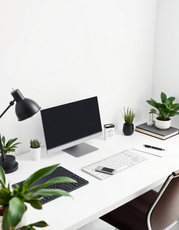 Workplace with computer, keyboard, stationery and potted plantsの写真素材