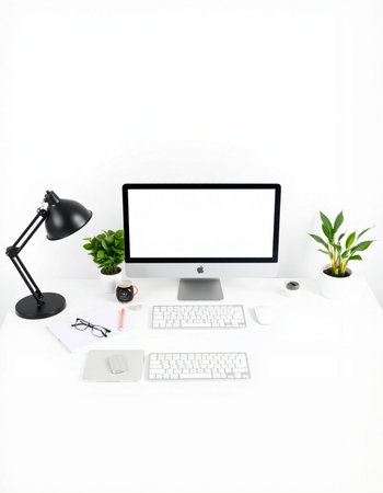 Modern workspace with computer, keyboard, mouse, coffee cup and plant.
