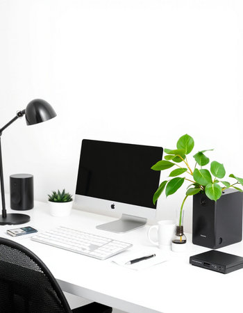 workplace with computer on white table and plant in pot on wall background