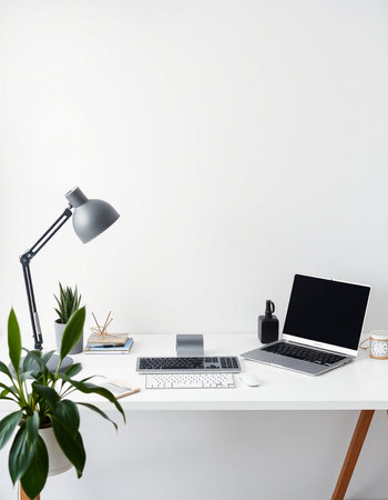 Front view of modern workplace with blank screen laptop, coffee cup, stationery and houseplant. Mock upの写真素材