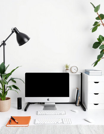 Workspace with computer, keyboard, stationery and plant on white tableの写真素材