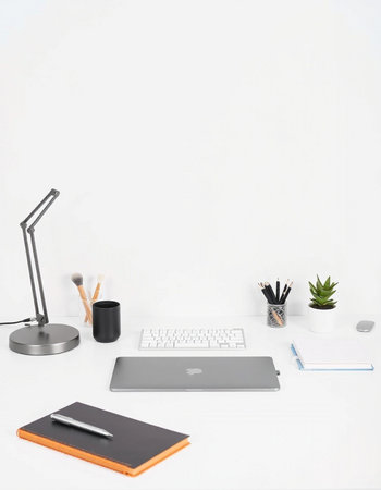 Modern workspace with laptop, stationery and coffee cup on white background