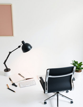 Minimalistic office workspace with computer, keyboard, notebook, lamp and plant