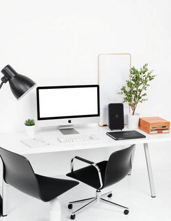 workplace with computer, lamp and other items on white wall background