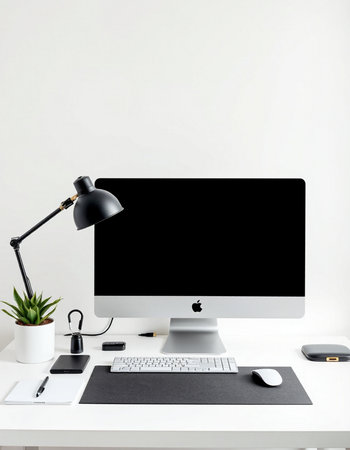 Workplace with computer, lamp and stationery on a white table