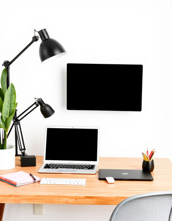 Modern workspace with blank screen laptop computer and office supplies on wooden table.