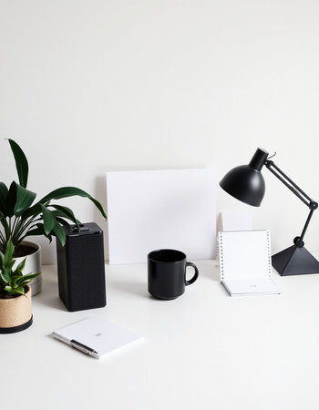 Modern workspace with blank paper, coffee cup, stationery and potted plant on white background