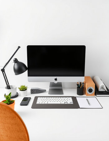 workplace with computer, lamp, stationery and plant on table