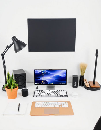 Modern workspace with computer, keyboard, mouse, notebook and accessories.