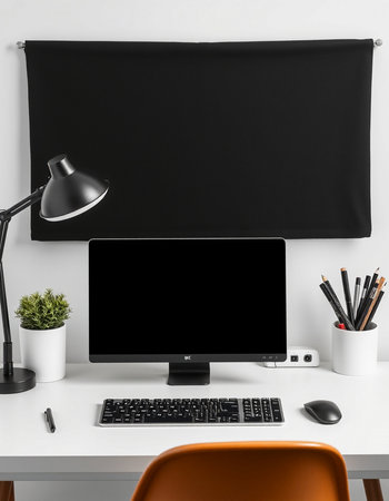 Workplace with blank screen computer, lamp and stationery on table