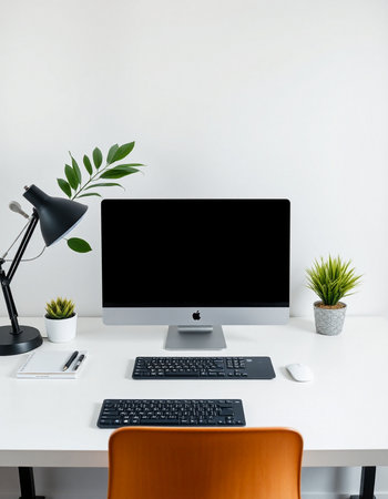 Modern workspace with blank computer monitor, keyboard, mouse, lamp and plant on white table