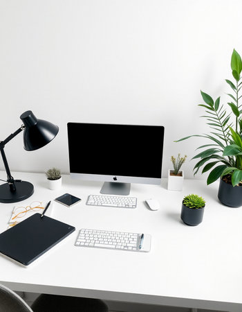 workplace with computer, blank screen, keyboard, lamp and plants