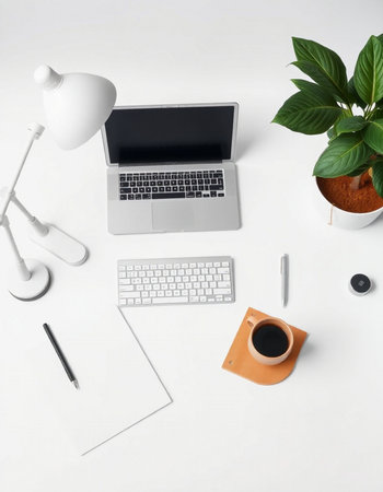 Modern workspace with laptop, coffee cup and decorations on white background. Flat lay, top view