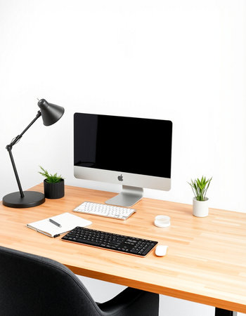 workplace with computer, keyboard, mouse, lamp and plant on table
