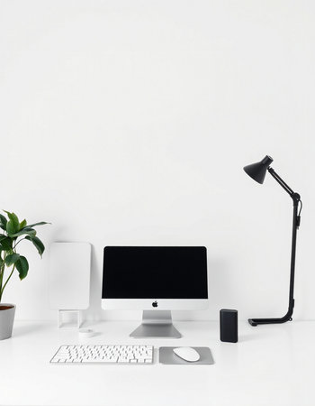 Modern workplace with computer, keyboard, mouse, lamp and plant.