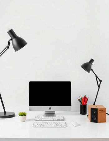 Workplace with computer, lamp and stationery on table near white wallの写真素材