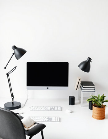 workplace with computer, stationery and plant on white wall background