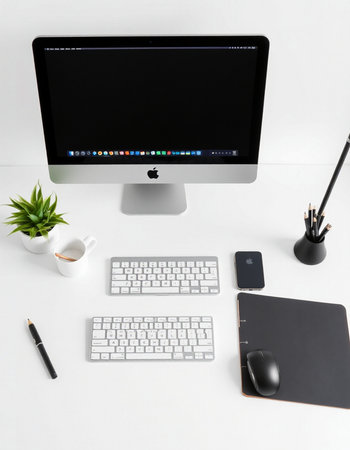Modern workspace with computer, supplies and coffee cup on white background.