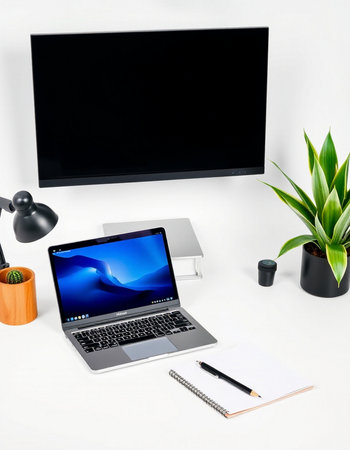 Modern workspace with blank screen laptop computer, coffee cup, notebook, stationery and potted...