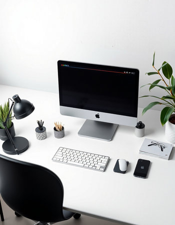 workplace with computer on white table in modern office with plant and lampの写真素材