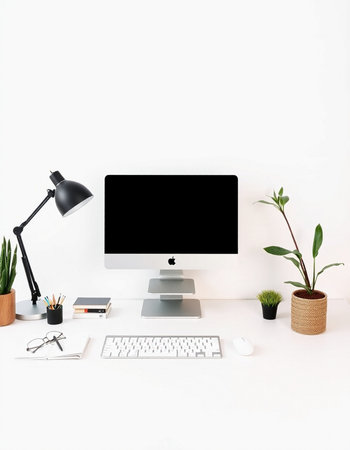 Minimal workspace with computer, stationery and plant on white background