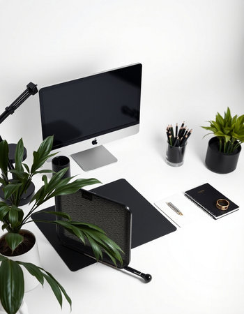 Creative workspace with computer, stationery and plant on white background