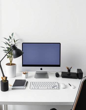 Workplace with computer, stationery and plant in pot on table