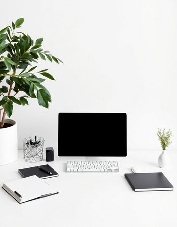 Modern workspace with blank screen computer, supplies and plant on white background