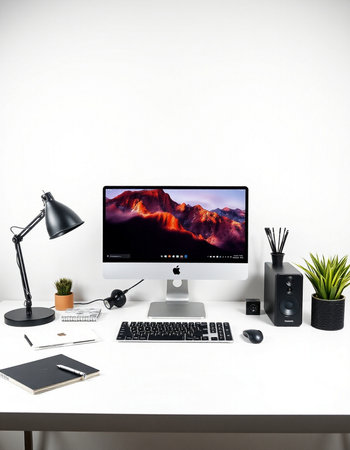 Workplace with computer, stationery and lamp on white table.