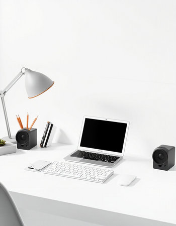 workplace with laptop, lamp and stationery on white wall background