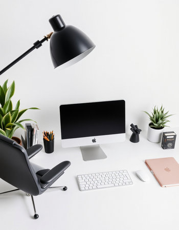 workplace with computer, lamp and stationery on white wall background