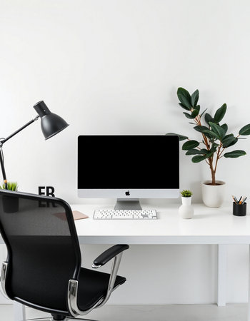 Workplace with computer, lamp and plant on white wall background.
