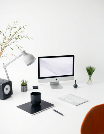 Modern workspace with computer, supplies and plant.