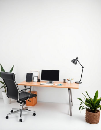 workplace with computer, lamp and plant on a white wall backgroundの写真素材