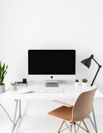 Minimalistic workspace with blank computer screen on white table.