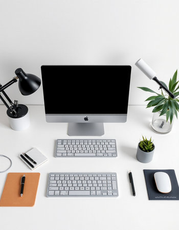 High angle view of modern workplace with computer, keyboard, mouse, stationery, coffee cup and other items on white backgroundの写真素材