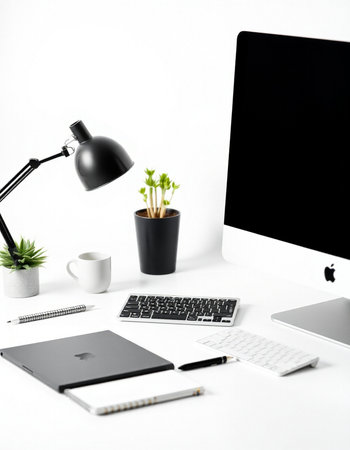 Modern workspace with computer, supplies and coffee cup on white background.