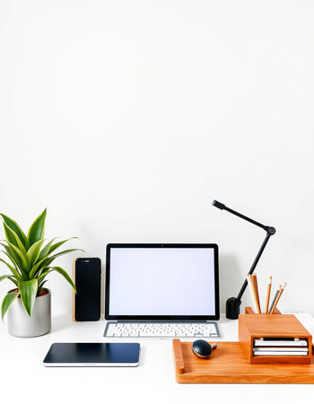 Modern workspace with blank screen laptop computer, coffee cup and office supplies on white...