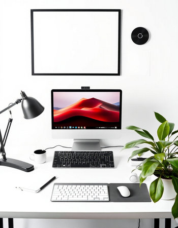 Modern workspace with computer, keyboard, mouse, lamp, coffee cup and plantの写真素材