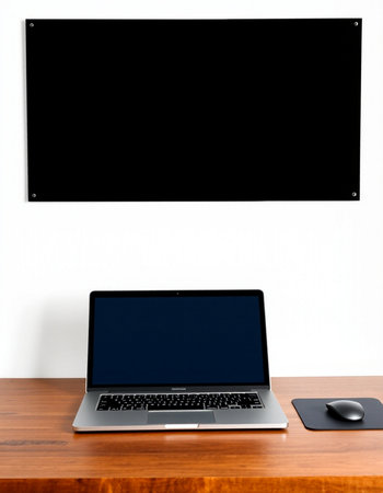 Laptop on wooden table with blank screen on white wall background.