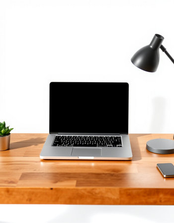 Laptop with blank screen on wood table and white wall background.