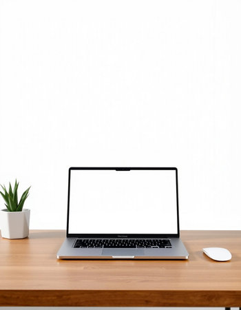 Laptop with blank screen on wooden table and white wall background.