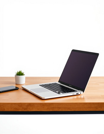 Laptop with blank screen on wood table with white wall background.