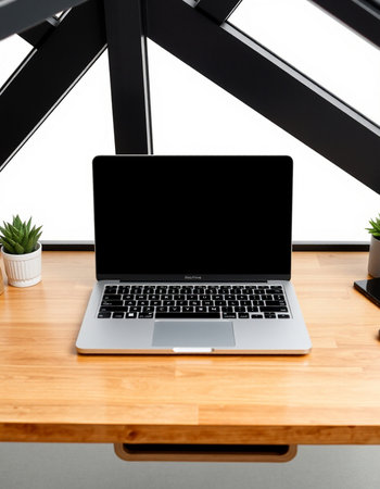 Laptop with blank screen on wooden table in office, stock photo
