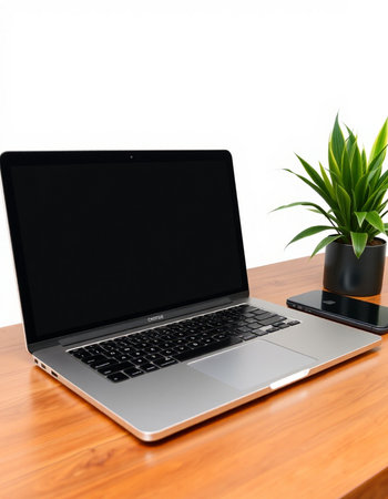 Laptop on a wooden desk with a plant in a pot.