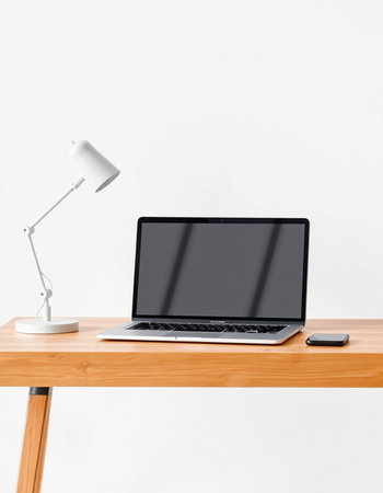 Laptop with blank screen on wooden table and lamp on white wall backgroundの写真素材