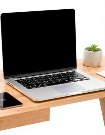 Laptop computer with blank screen on wood table and white background.